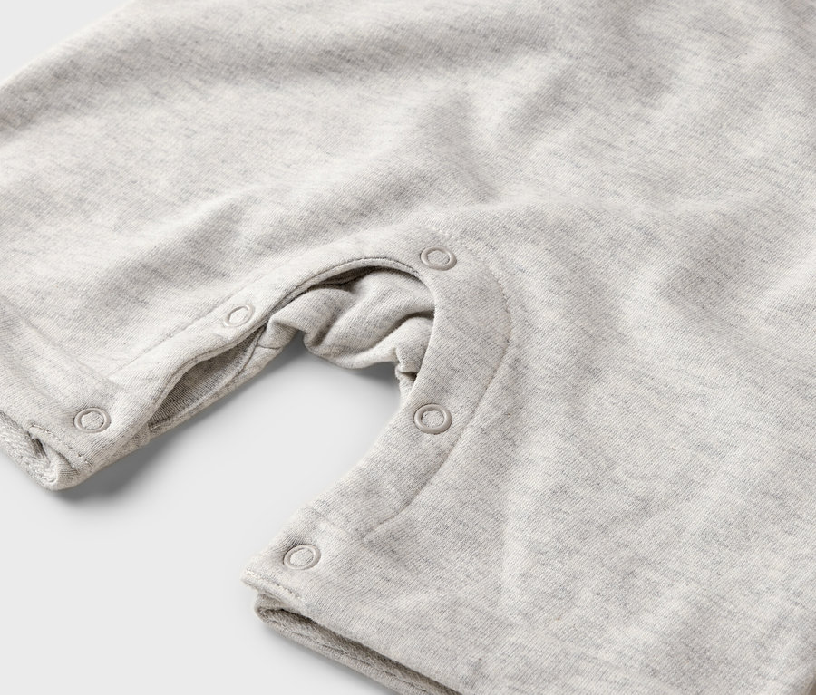 Detailaufnahme eines hellgrauen Baby-Spielanzugs mit Druckknöpfen.