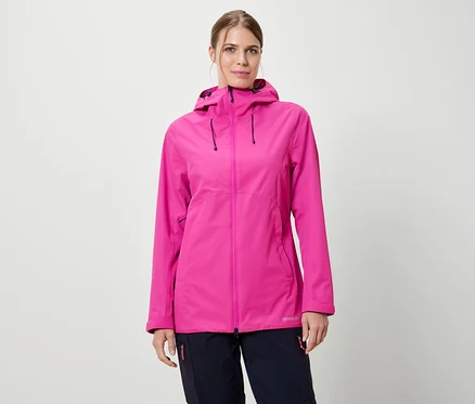 Frau trägt eine pinke Regenjacke mit Kapuze und dunkelblaue Hosen vor einem weißen Hintergrund.