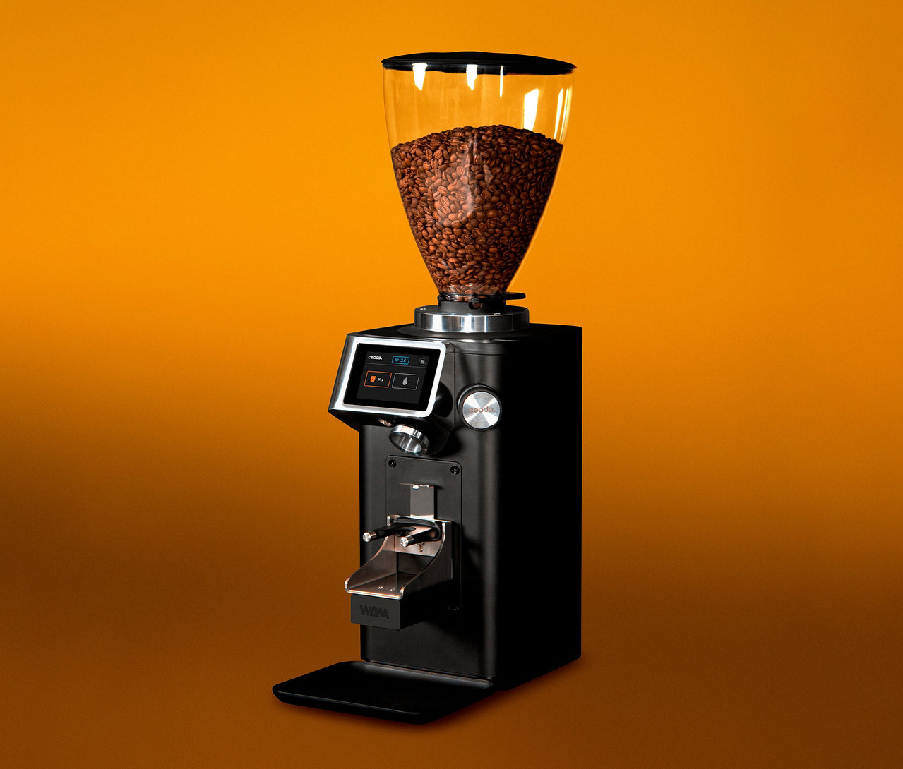 Eine schwarze Kaffeemühle mit einem durchsichtigen Behälter voller Kaffeebohnen vor einem orangefarbenen Hintergrund.