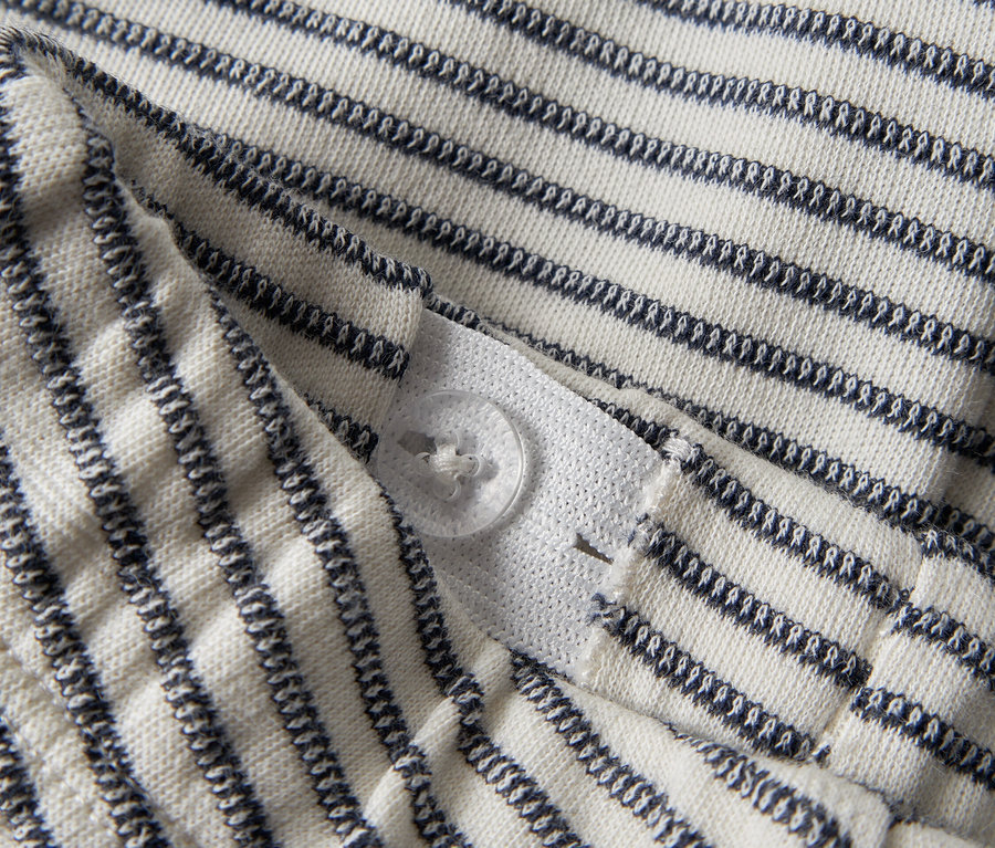 Detailansicht eines gestreiften Stoffes mit Knopfverschluss.