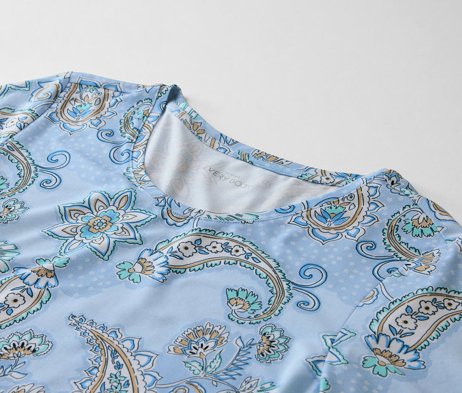 Nahaufnahme eines hellblauen Oberteils mit einem blassblauen Paisley-Muster.