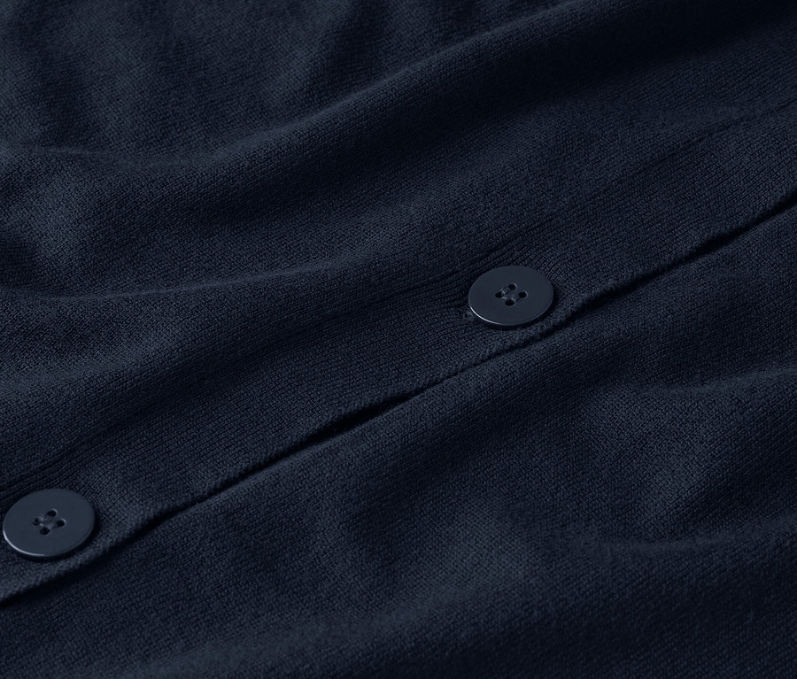 Nahaufnahme einer marineblauen Strickjacke mit Knöpfen.