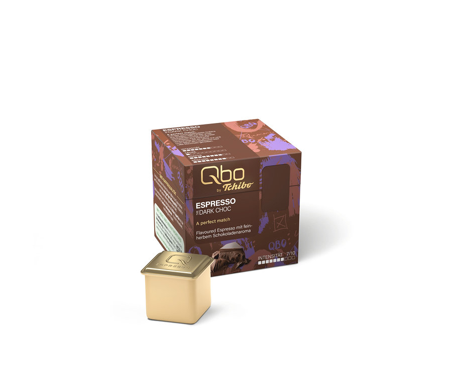Qbo Flavoured Espresso Dark Choc Packung und eine goldene Kapsel. Die braun-violette Packung zeigt den Text "ESPRESSO DARK CHOC" und die Intensität 7/10.