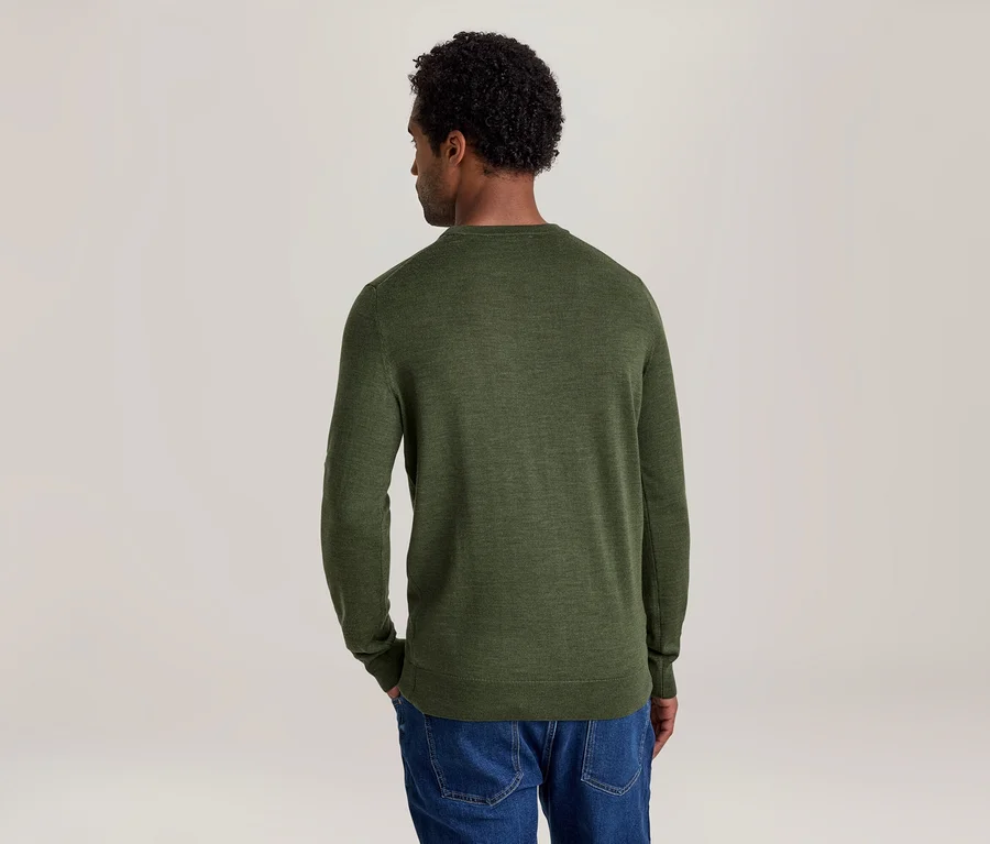 Mann von hinten, der einen grünen Langarmpullover und blaue Jeans trägt. Sein Kopf ist leicht nach links gedreht.