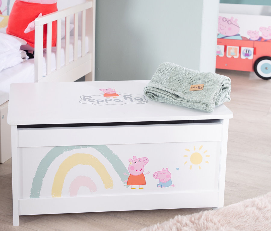 Abbildung einer Spielzeugkiste mit Peppa Pig-Motiv und einer grünen Decke darauf.