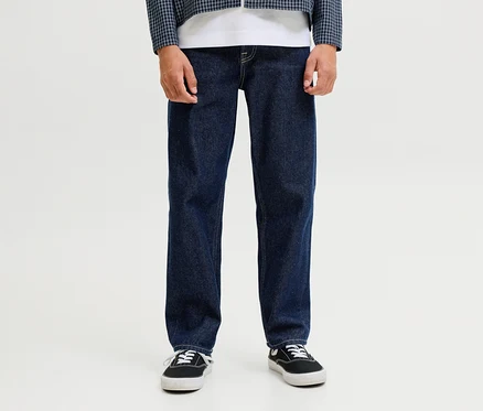 Eine Person trägt dunkelblaue Jack&Jones JJOriginal Chris Jeans, ein weißes T-Shirt, eine blau-weiß karierte Jacke und schwarze Sneaker.
