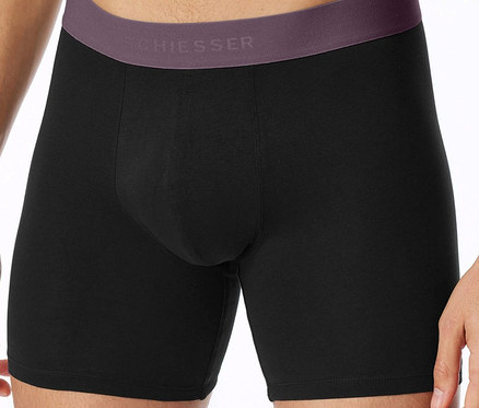 Mann trägt schwarze CHIEESSER Boxershorts mit violettem Bund.