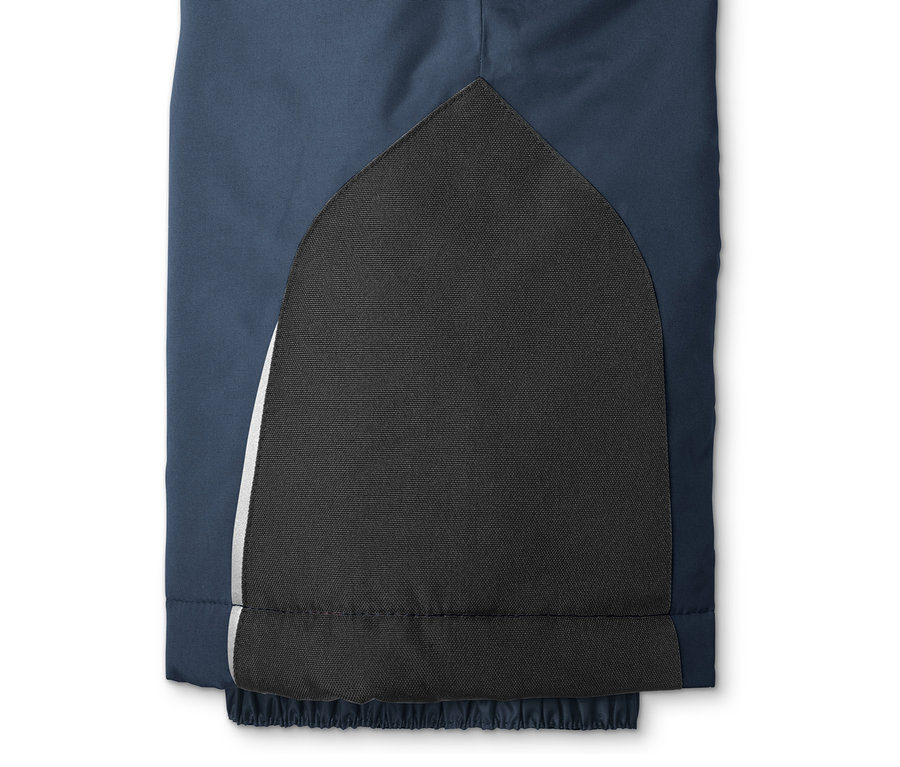 Detail einer Skihose mit einem schwarzen, verstärkten Bereich am Bein.