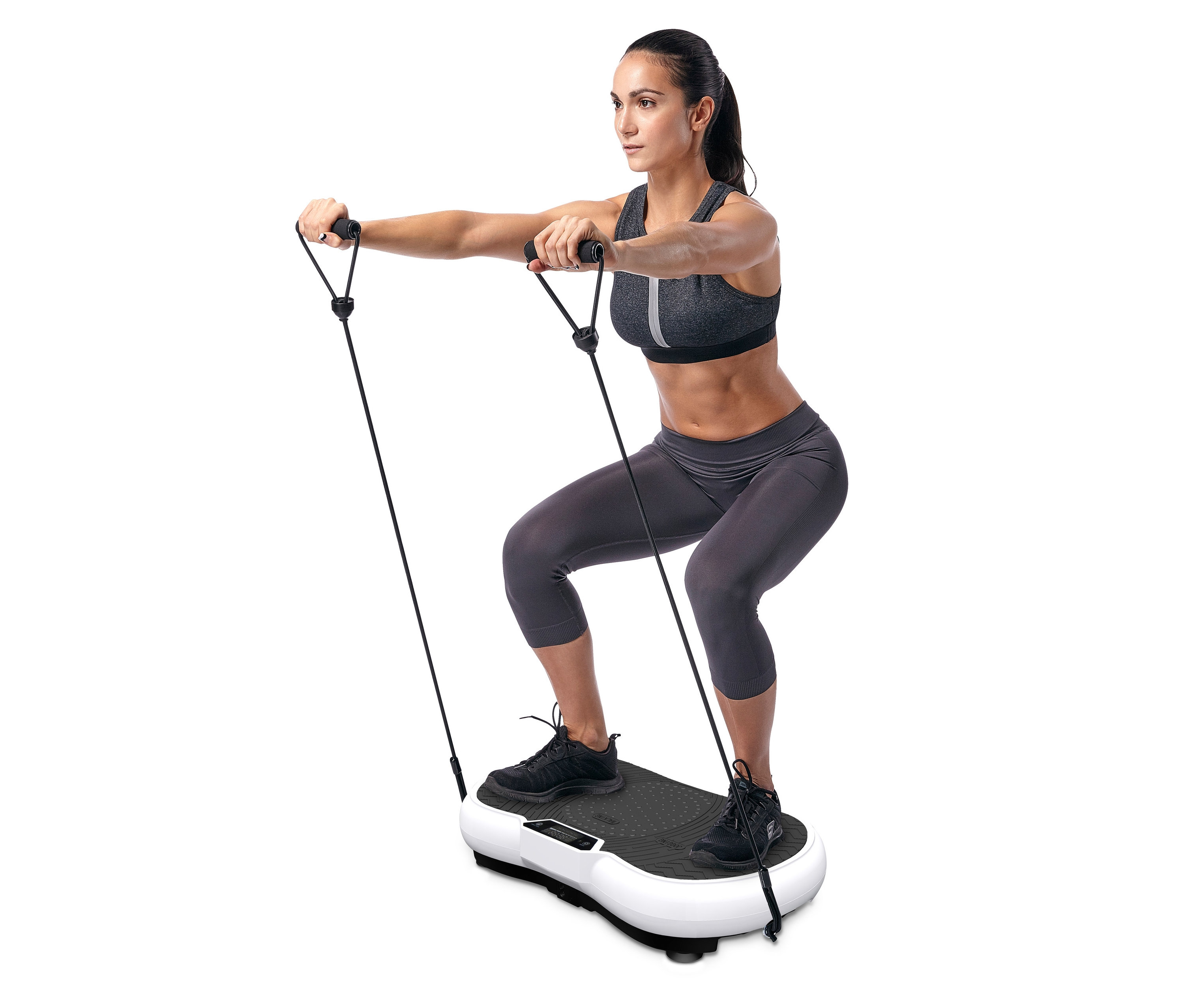 Frau macht Kniebeugen auf einem Vibrationsboard.