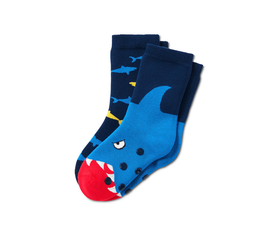 Zwei Paar Antirutsch-Socken. Ein Paar ist dunkelblau mit gelben und blauen Haien. Das andere Paar ist blau mit einem Haikopf mit rotem Maul.