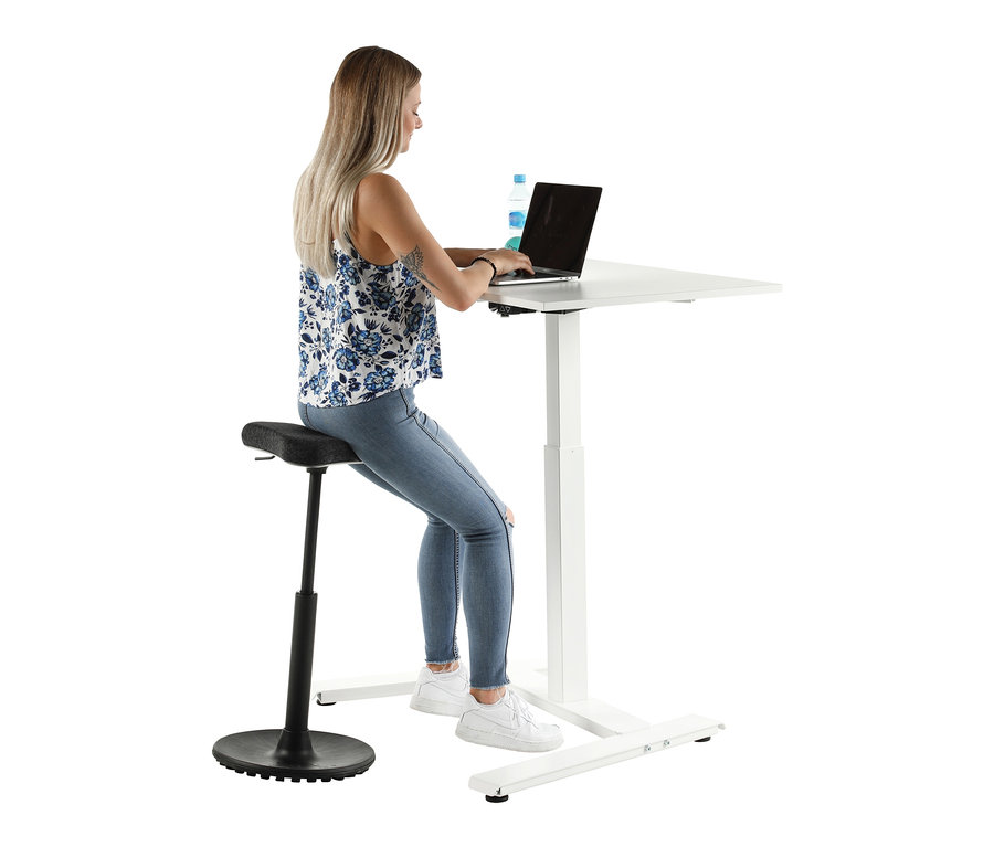 Frau sitzt an einem weißen Topstar E-Tisch »Single« auf einem Barhocker und tippt auf einem Laptop.