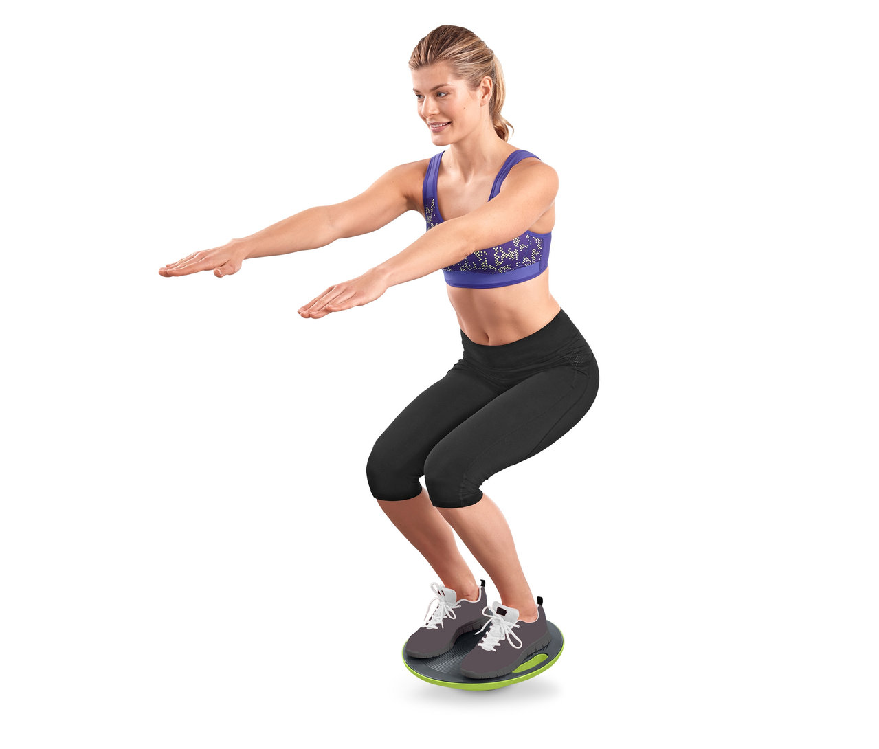 Frau macht Kniebeugen auf einem Balance-Board.