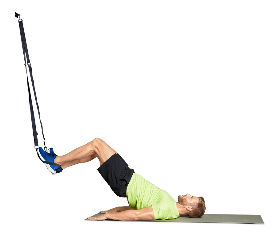 Mann trainiert mit Schlingentrainer.