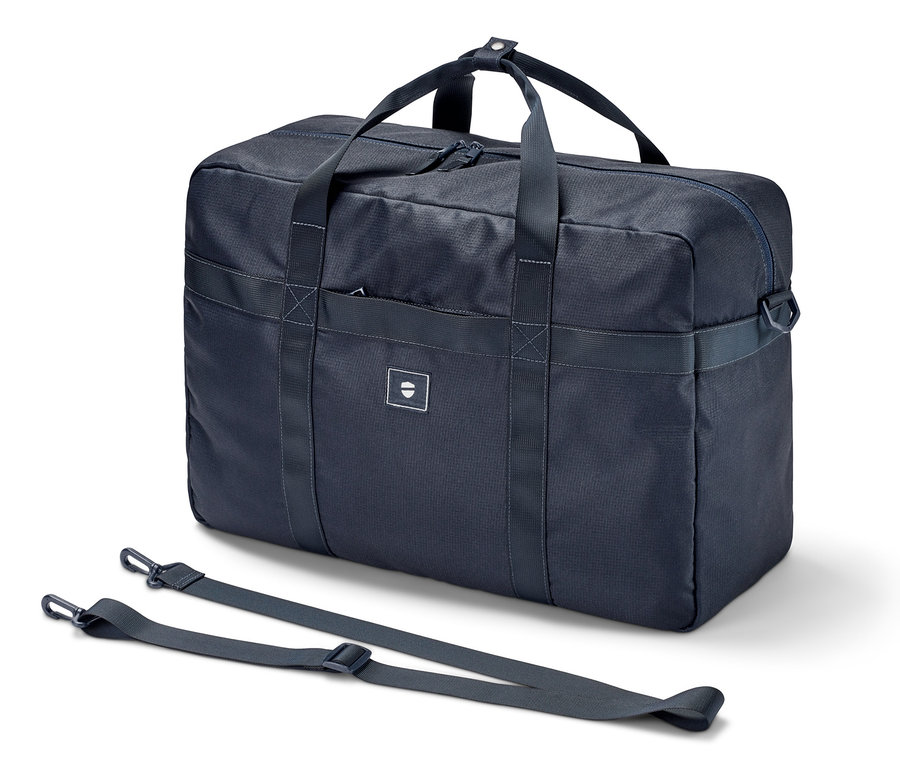 Eine dunkelblaue Weekender Reisetasche mit Gurt liegt auf einem weißen Hintergrund.