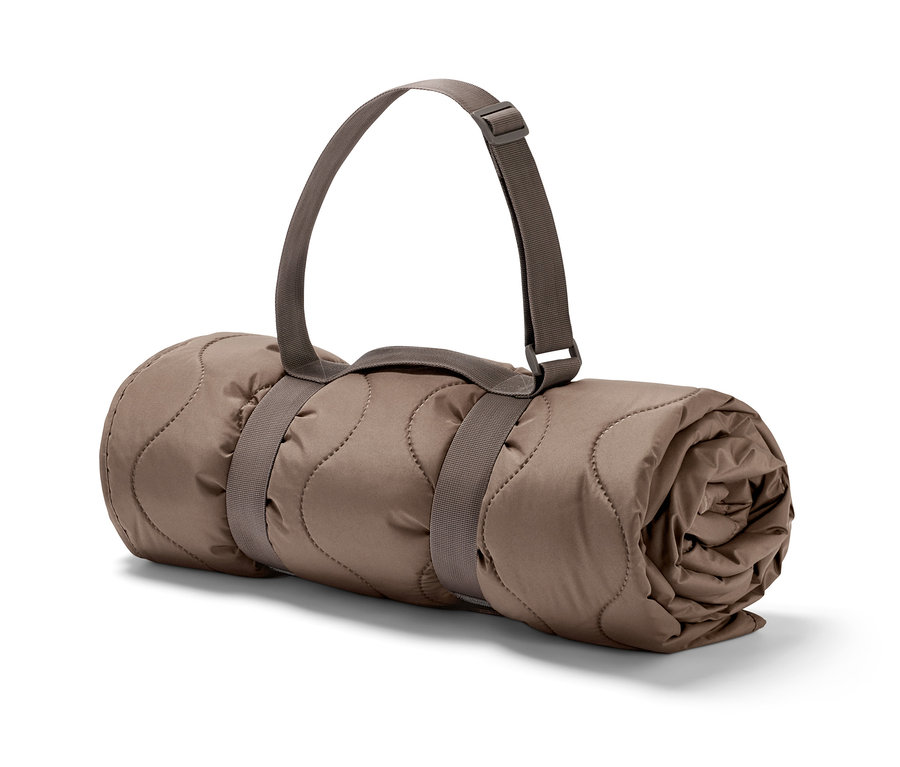 Eine zusammengerollte Outdoor-Thermodecke mit Riemen.