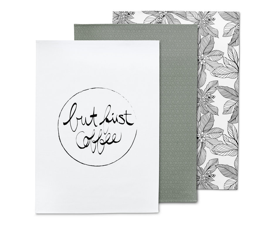 Ein Set aus 3 Geschirrtüchern: ein weißes mit der Aufschrift "but first coffee", ein graugrünes mit geometrischem Muster und ein weißes mit schwarzen Blättern.