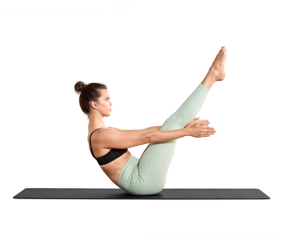 Frau macht eine Yogaübung auf einer schwarzen Yoga- und Fitnessmatte.