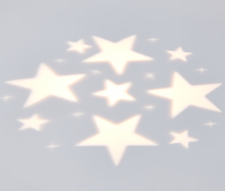 Auf eine Wand projiziertes Licht von einer LED-Projektor-Lichterkette in Form von Sternen.