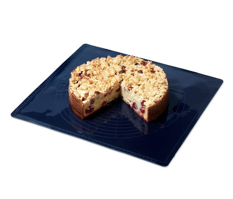 Angeschnittener Streuselkuchen auf blauer Dauerbackmatte.