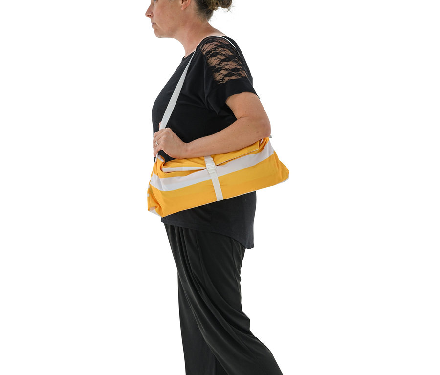 Frau trägt gelbes Strand-Sonnensegel über der Schulter.