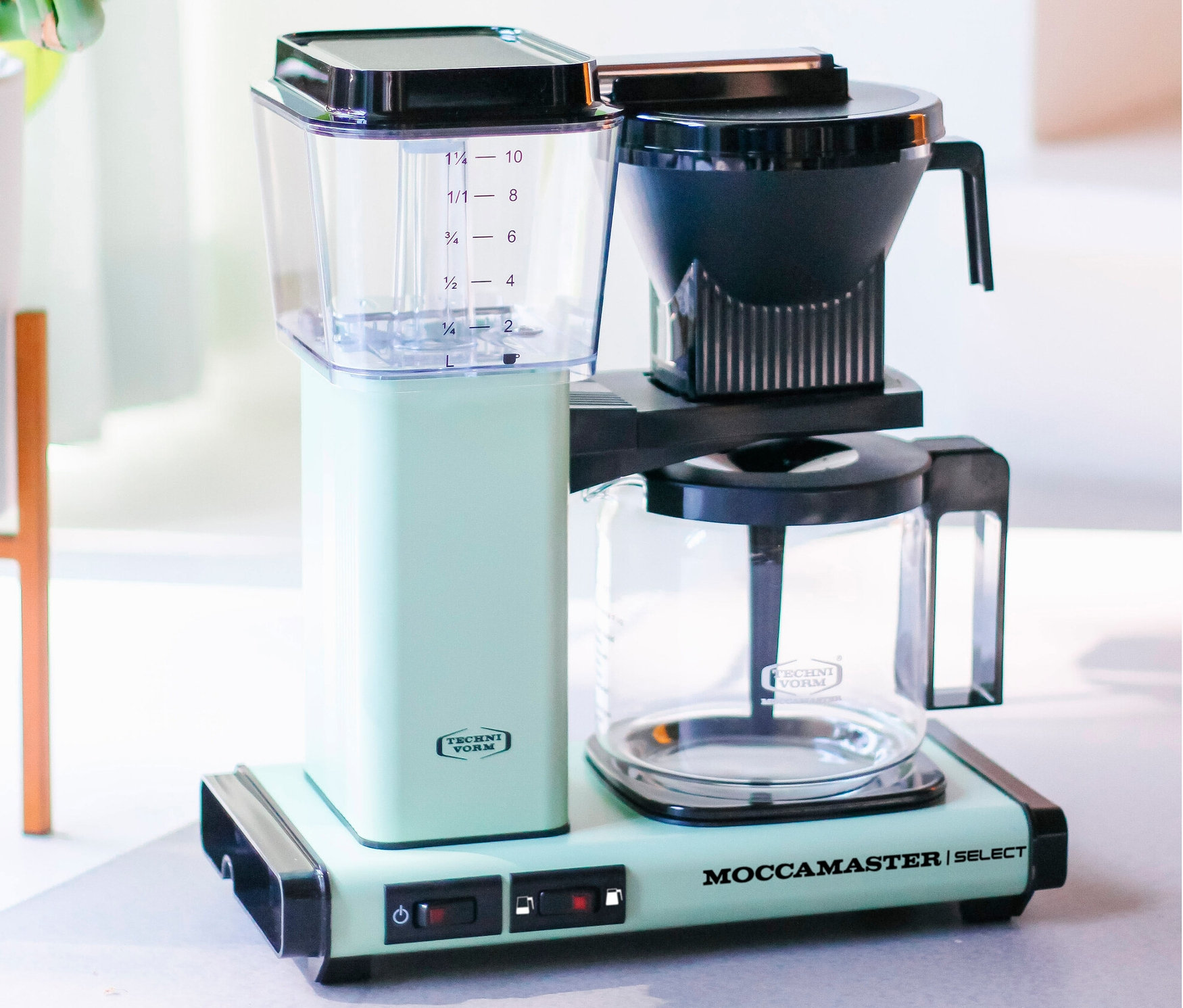 Pastellgrüne Filterkaffeemaschine Moccamaster KBG Select steht auf einem Tisch.