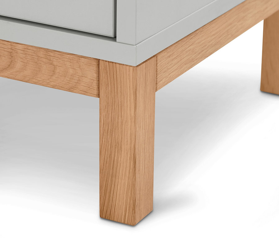 Detailansicht eines hellgrauen Bad-Hochschranks »Eklund« mit Holzfüßen.