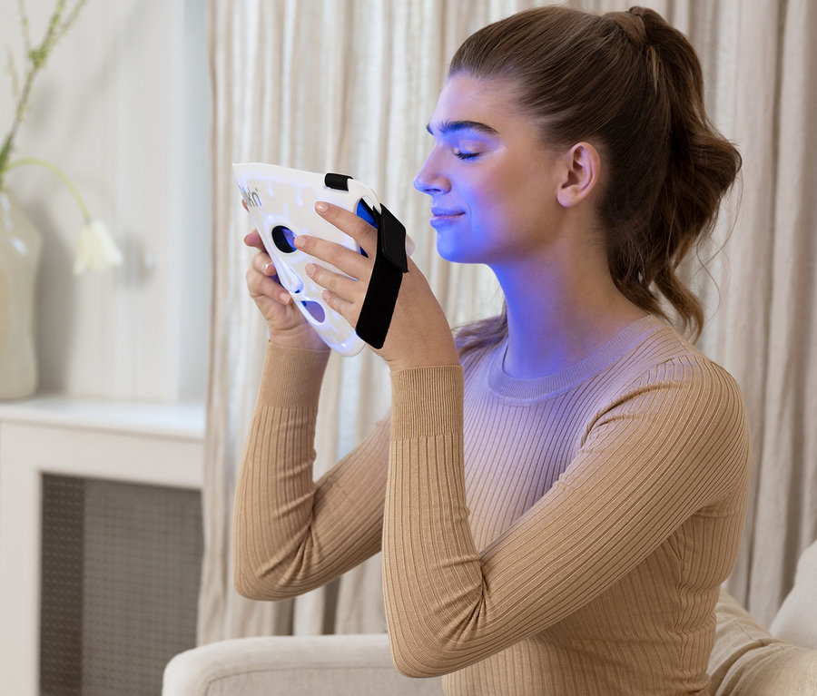 Frau hält Silk'n LED-Gesichtsmaske 100.