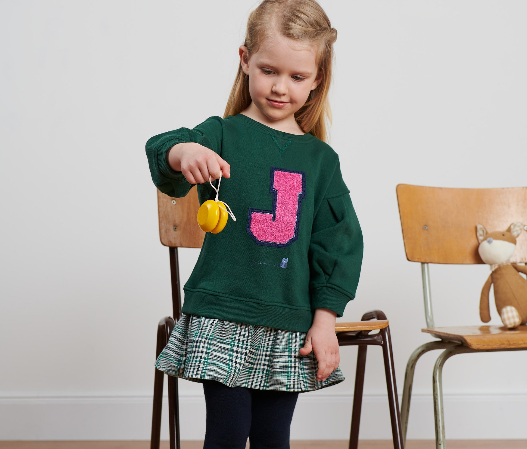 Mädchen hält ein Jojo. Sie trägt ein Kleid.