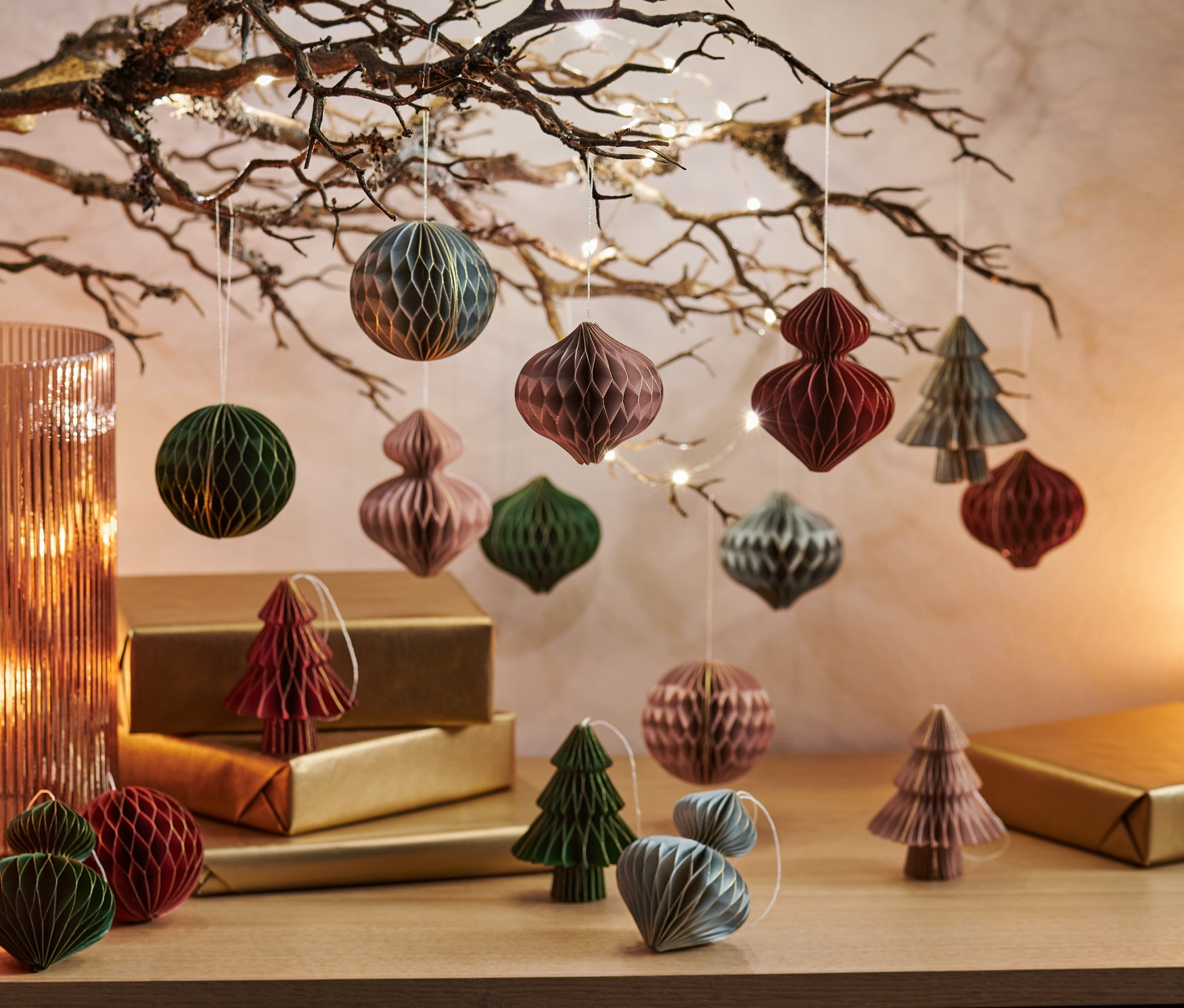 Weihnachtsbaumschmuck, 16er-Set, hängt an einem Ast und liegt auf goldenen Päckchen.