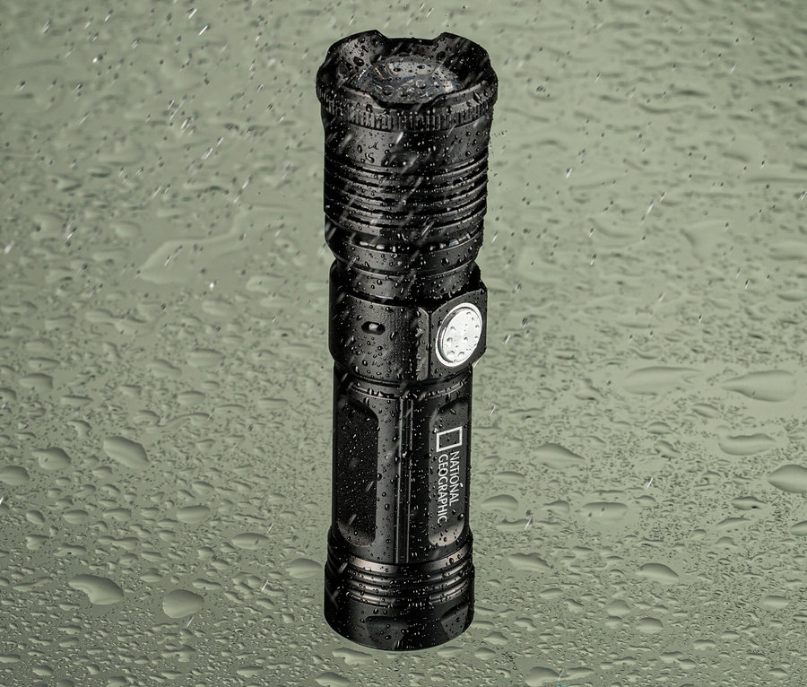 Schwarze National Geographic ILUMINOS 1000 LED-Zoom-Taschenlampe auf regnerischer Oberfläche.
