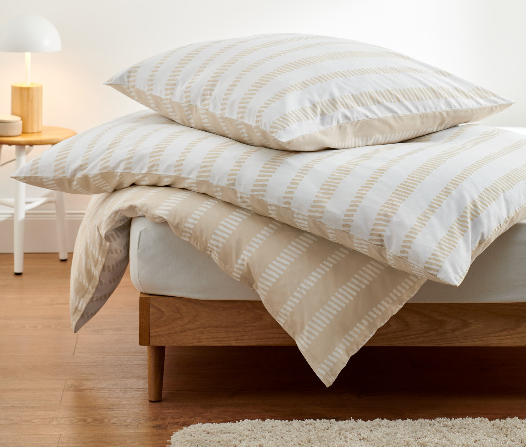 Premium-Baumwoll-Bettwäsche in Normalgröße und Übergröße liegt auf einem Bett.