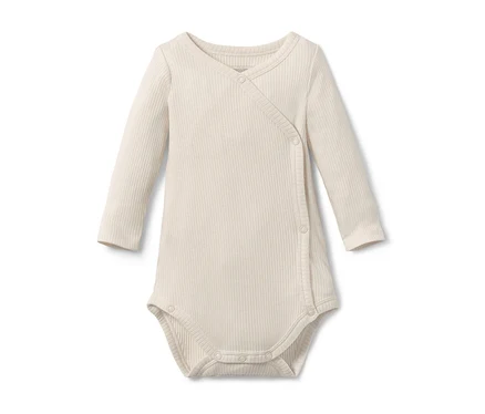 Ein liegender, langer beiger Baby-Body mit Modal.