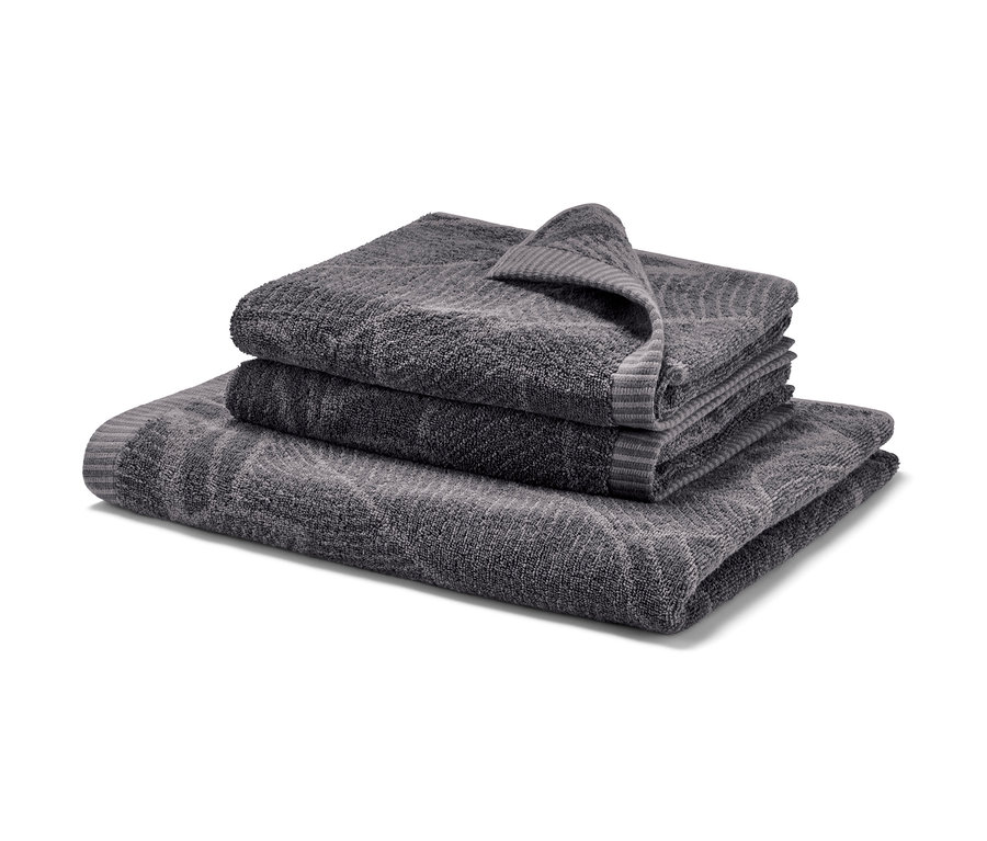 Ein Jacquard-Badetuch und zwei Jacquard-Handtücher in Anthrazit sind aufeinander gestapelt.