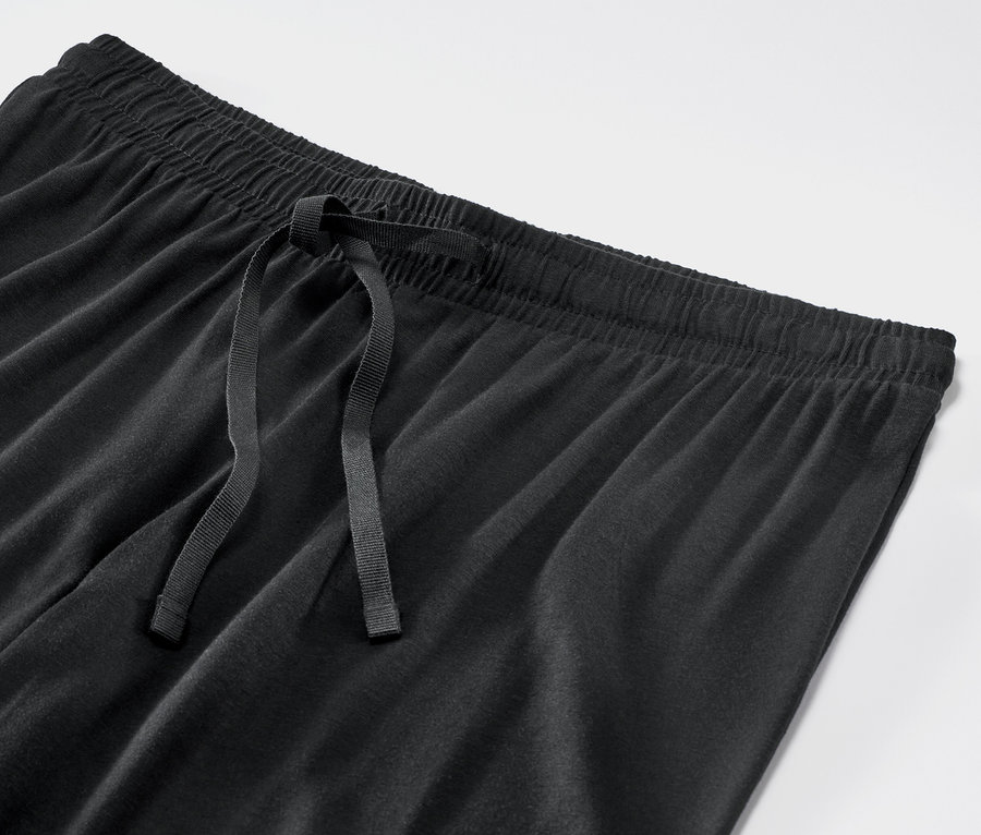 Detailaufnahme einer schwarzen Pyjamahose mit Kordelzug.