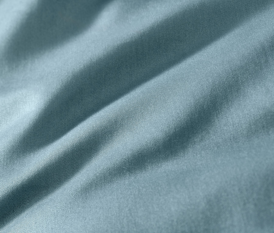 Nahaufnahme von blauer Baumwollsatin-Bettwäsche.