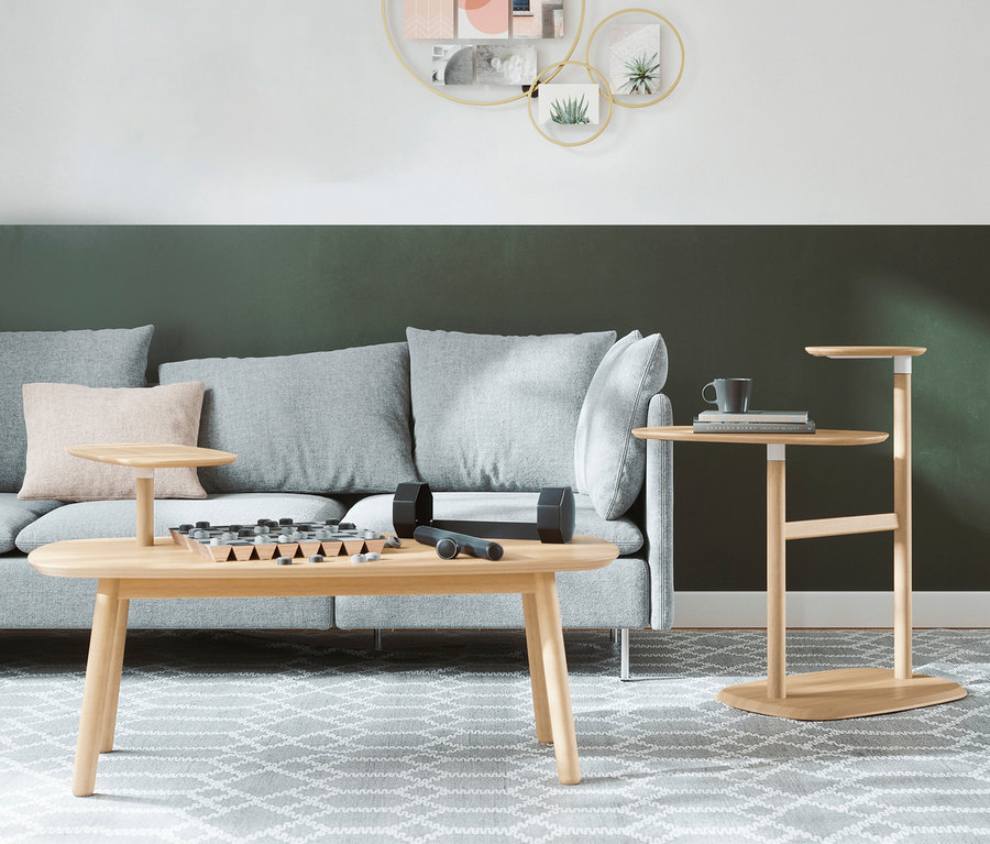 Wohnzimmer mit grauem Sofa, hellem Couchtisch, auf dem ein Hantelset und ein Brettspiel liegen.