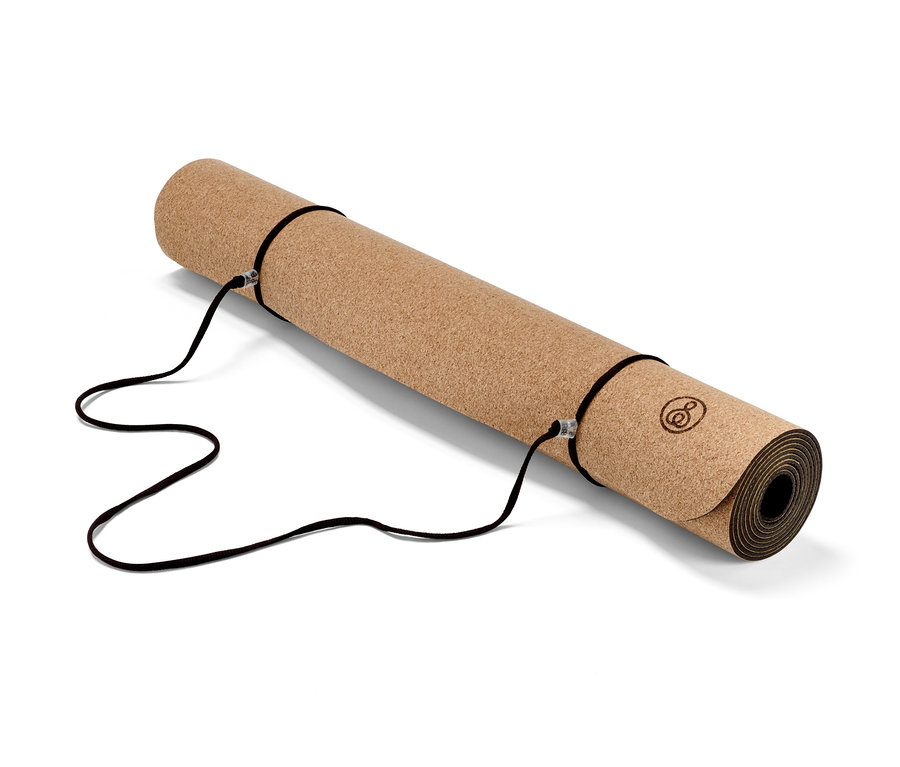Eine zusammengerollte Kork-Yoga-und-Fitnessmatte mit schwarzen Gurten.