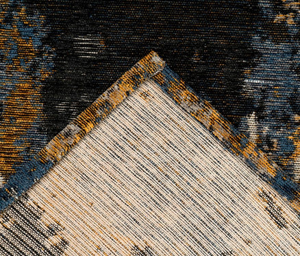 Detailaufnahme einer Ecke des mehrfarbigen Kurzflorteppichs.