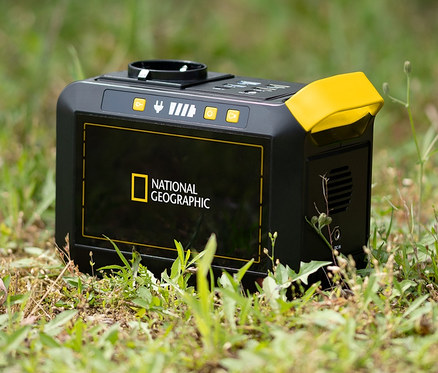 Eine schwarz-gelbe National Geographic Mobile Power Station liegt im Gras.