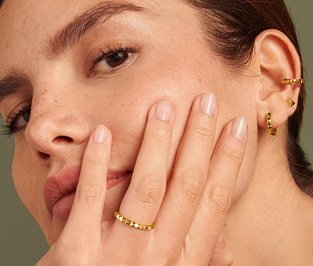 Frau mit 925 Silber Ring Pyramide am Ringfinger, 925 Silber Creolen Pyramide und 925 Silber Earcuff Pyramide.