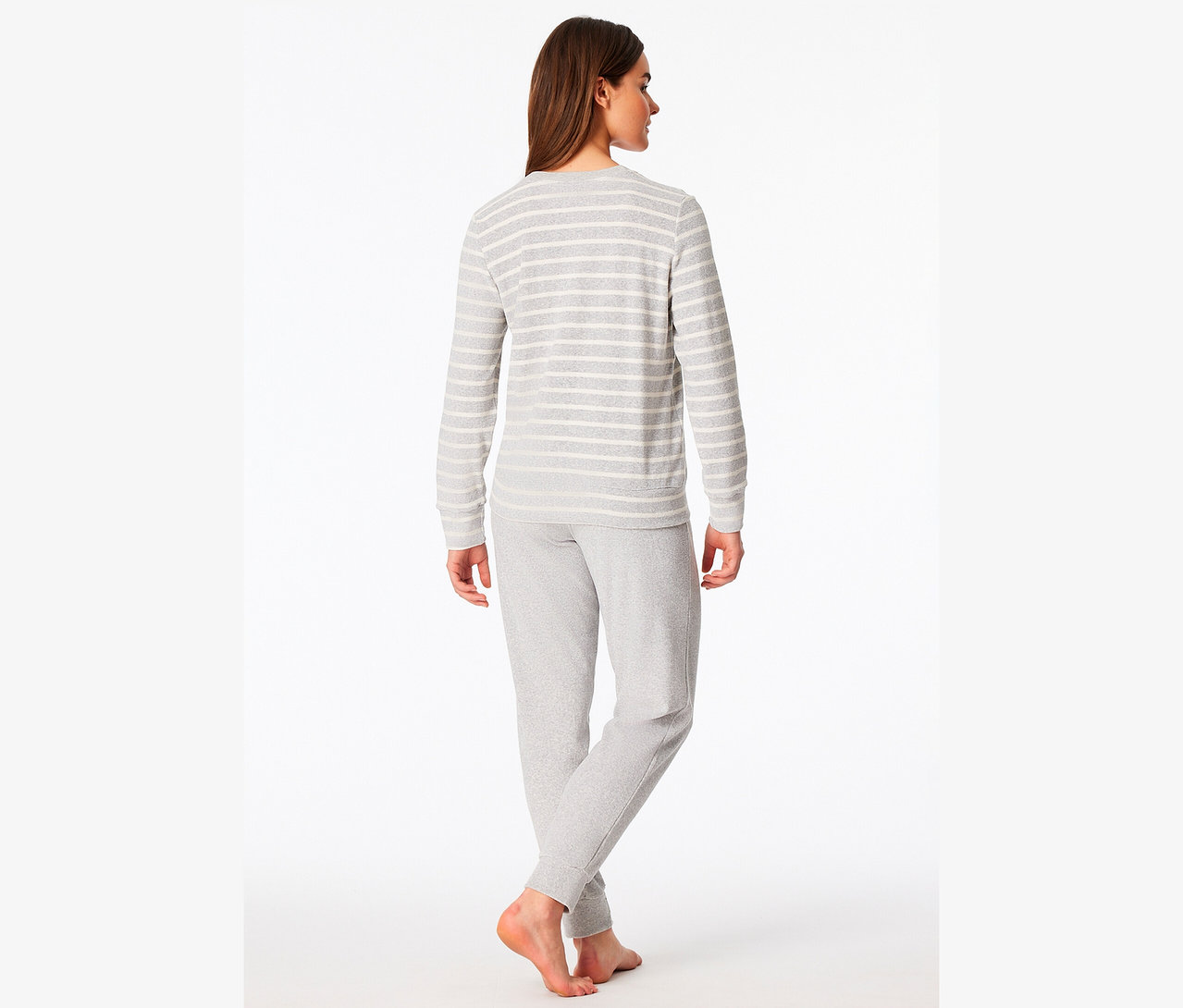 Frau steht mit dem Rücken zum Betrachter und trägt ein grau gestreiftes Langarmshirt und graue Jogginghose.