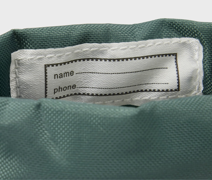 Detail von Kinder-Gummistiefeln mit Tier-Alloverprint und einem Etikett für Name und Telefon.