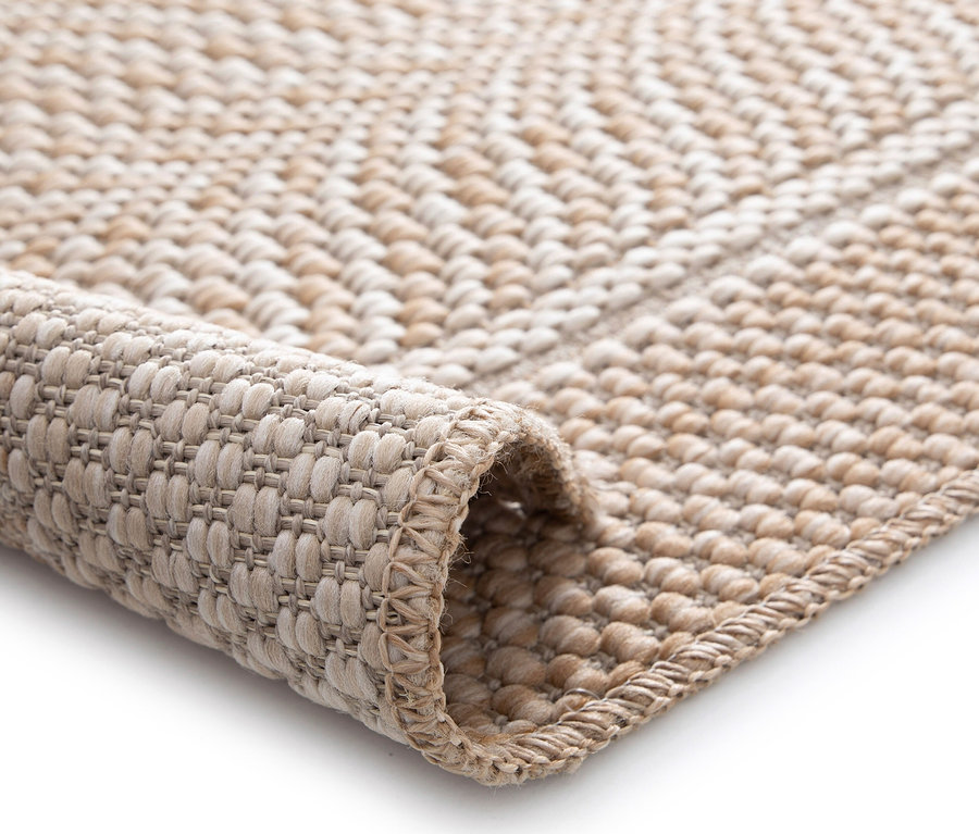 Detailansicht eines beigen »Twine« Teppichs im Fischgrätmuster.