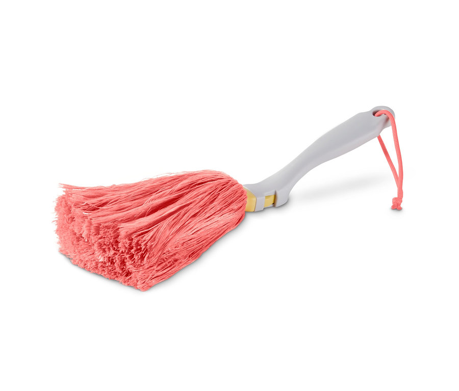 Ein Staubwedel mit rosa Fransen und grauem Griff liegt auf einem weißen Hintergrund. Der Aufsatz des Staubwedels ist dicht und hat eine unregelmäßige Form.