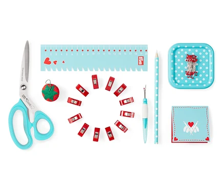 Schere, Stecknadeln, Maßband, Nahttrenner, Klemmen und andere Utensilien aus dem Prym Starter-Set Nähen »Love«.