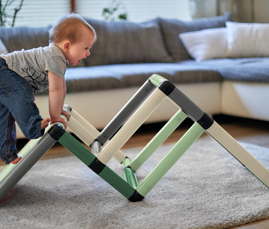 Kleinkind klettert auf ein Quadro-Home-BEGINNER-Set im Wohnzimmer.