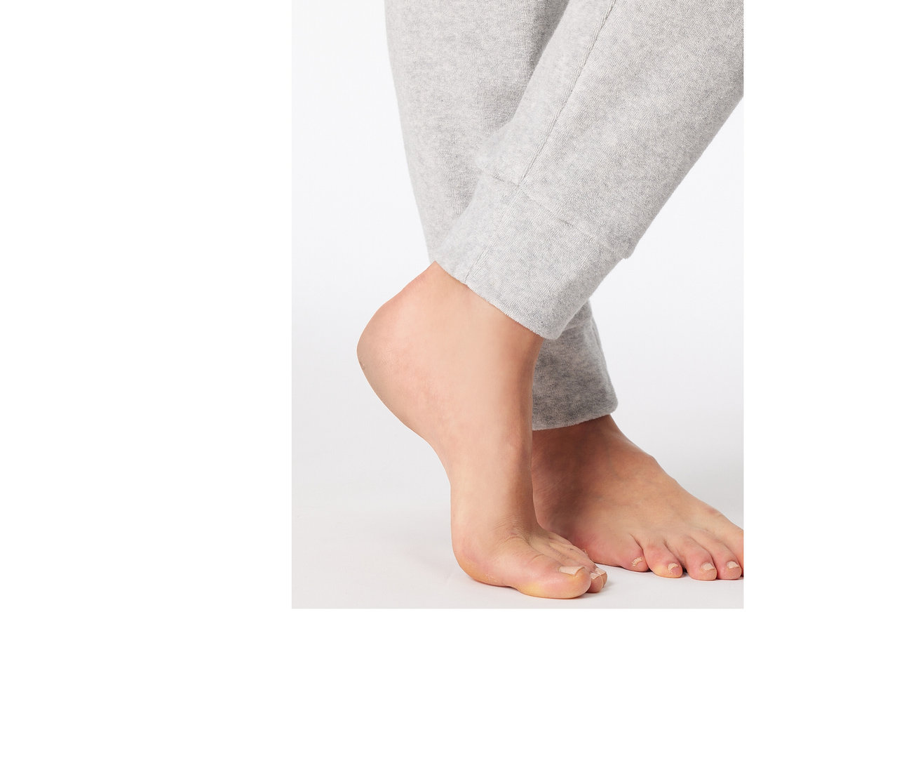Füße einer Person, die eine hellgraue SCHIESSER Frottee-Pyjamahose trägt.