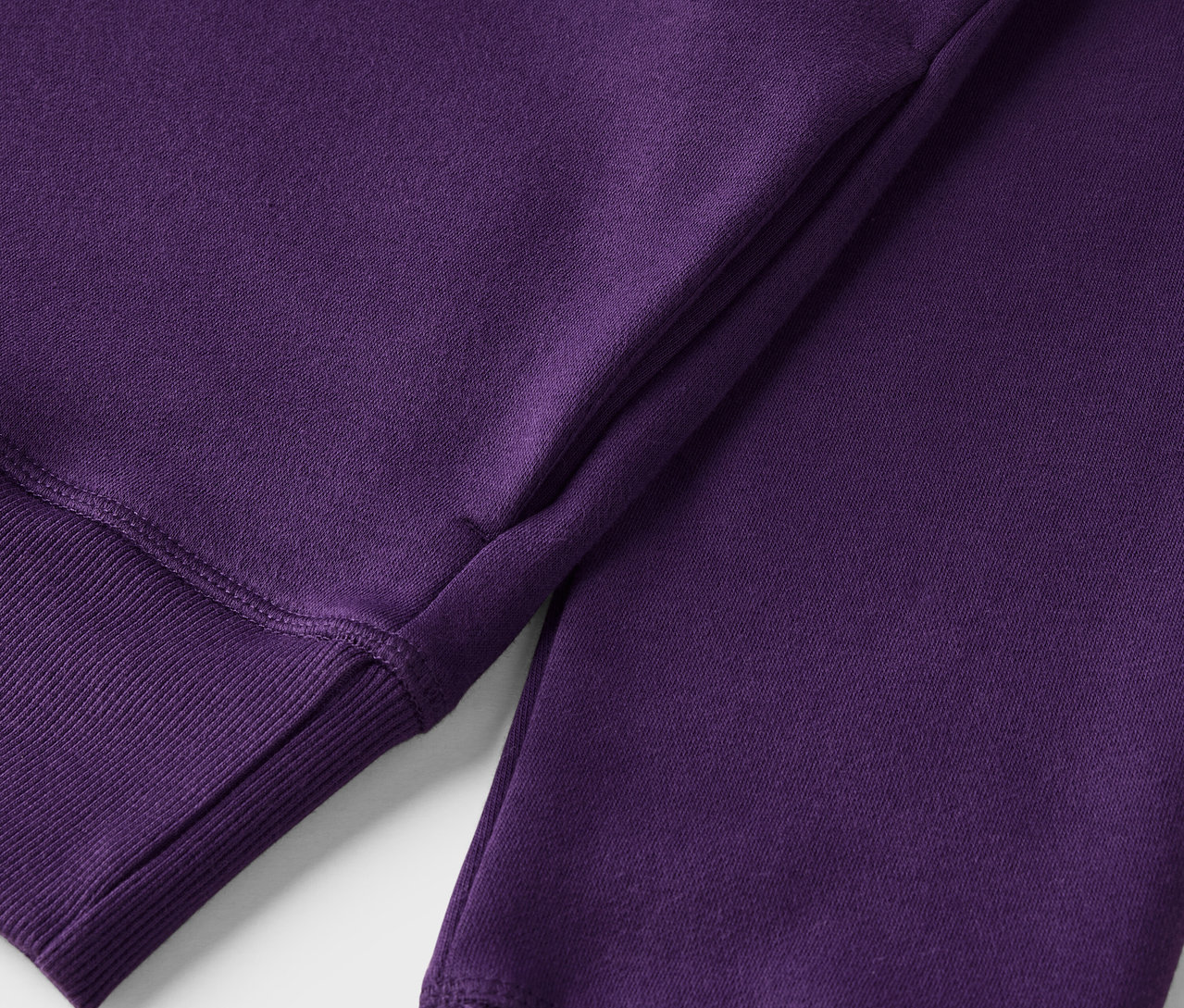 Detailansicht eines lila Sweatshirts mit geripptem Saum.
