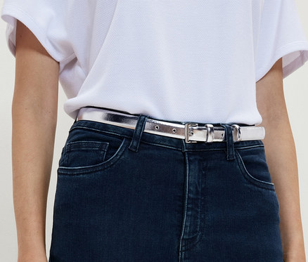Frau trägt Jeans und einen Gürtel.