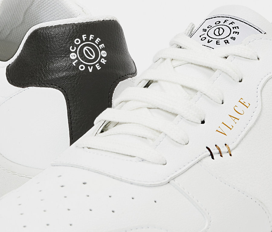 Detailaufnahme eines weißen Tchibo x VLACE Coffee Lover Sneakers.